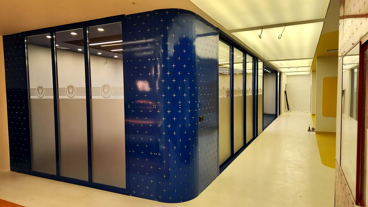 TED Üniversitesi Teacher+ laboratuvarı: lacivert delikli panel kaplamalı cam bölmeli odalar